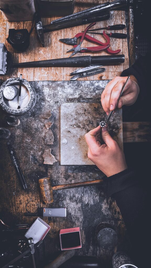 Jeweler hand-finishing a diamond ring on the workbench, representing Apex Jewelry Design’s craftsmanship